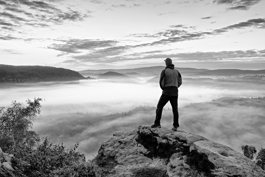 Man looking out over mountain contemplating life