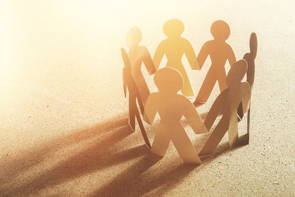 Paper cut outs of people holding hands in racial unity