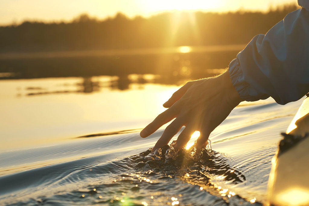 man slowly dragging hand in water
