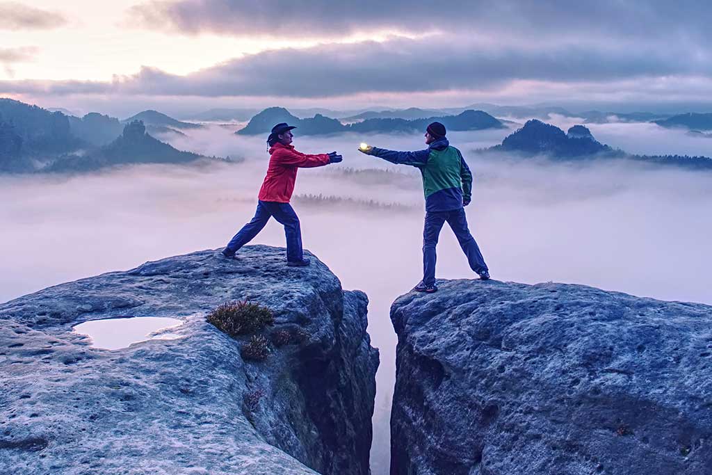 One person passing along a light to another