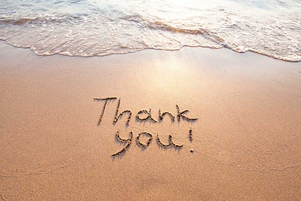 "Thank You!" written in the sand