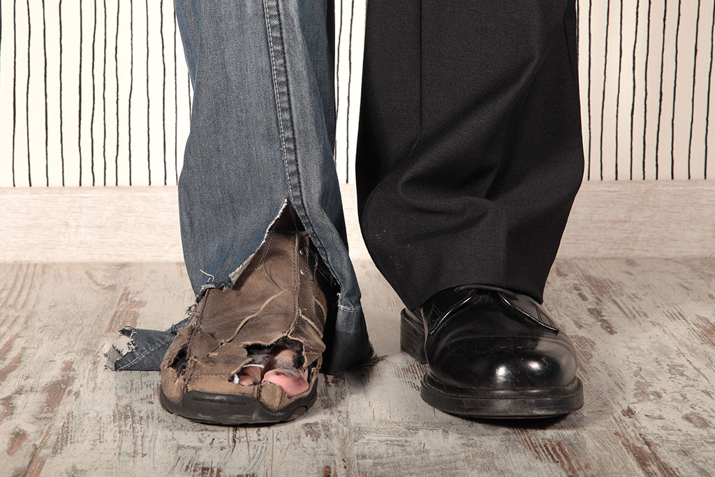 man with one leg in clothing of a poor person and the other dressed up
