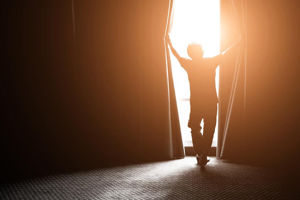 man opening curtains - hope