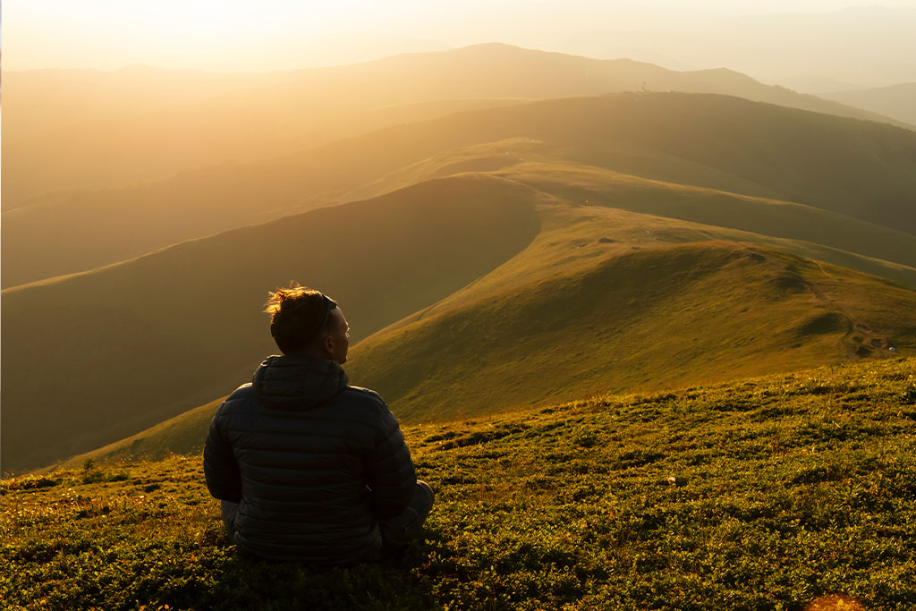 Man looking out on the hills contemplating his life