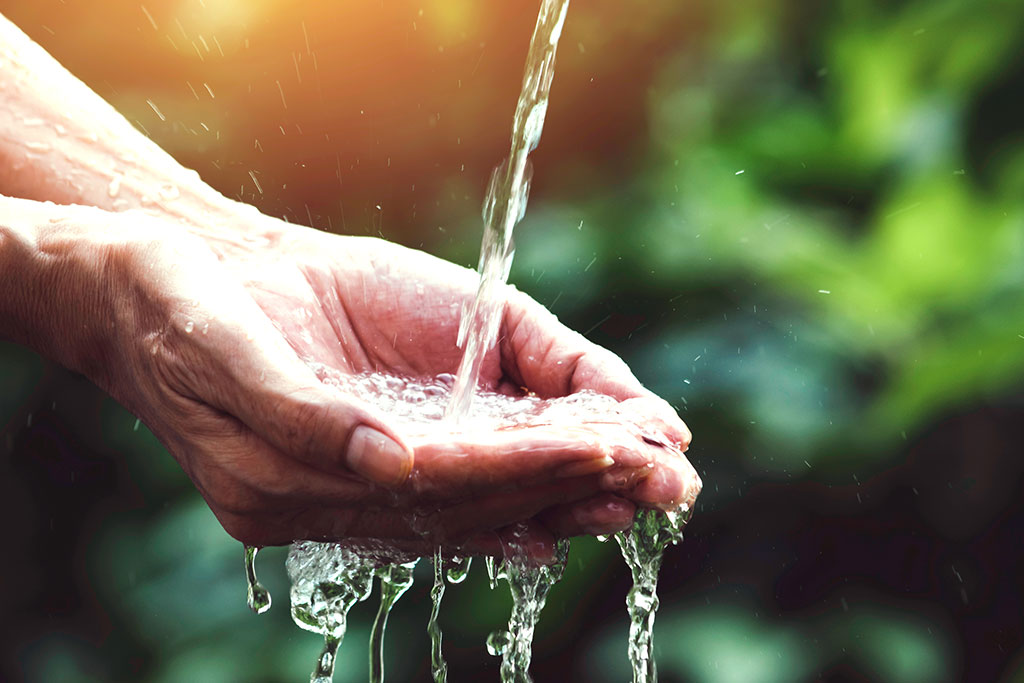 Woman catching water from a well
