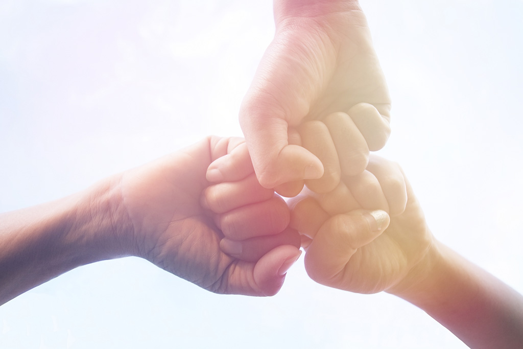 3 people fist bumping working together
