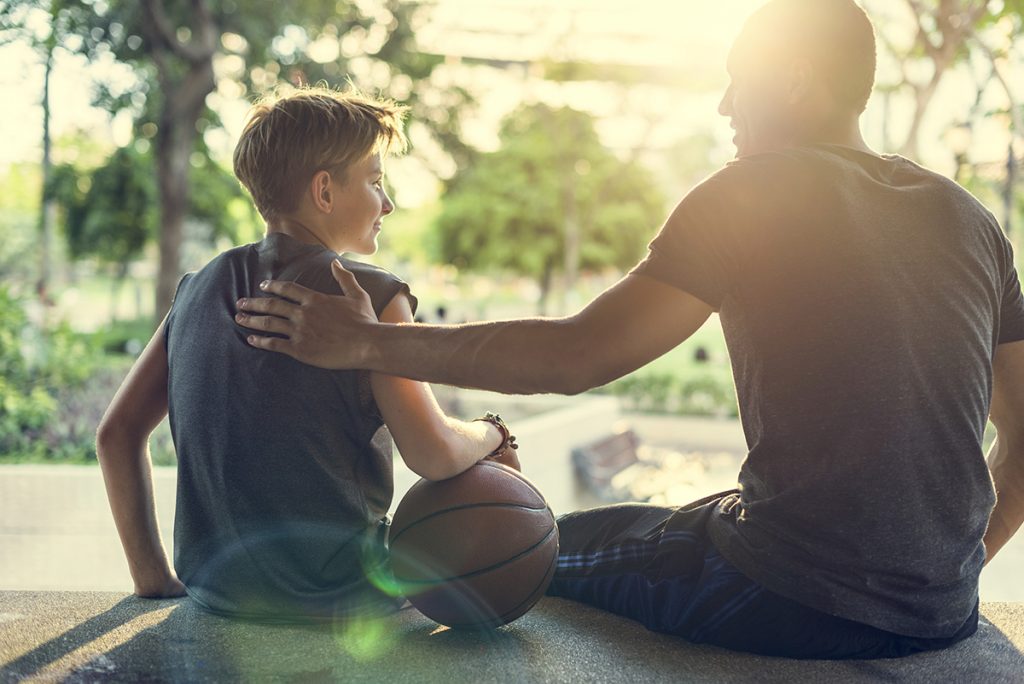 Dad talking with his son encouraging him after a game