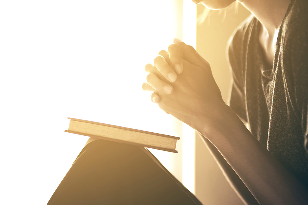 woman praying with Bible